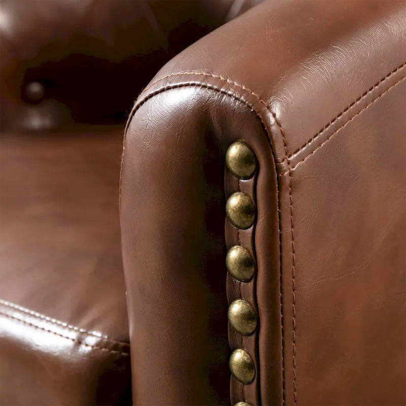Fauteuil club en similicuir avec accoudoirs encastrés et garniture cloutée